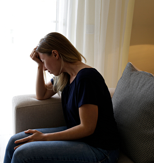 A woman sits with her head in her hand in frustration