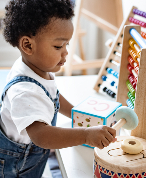 A toddler playing with blocks and other toys