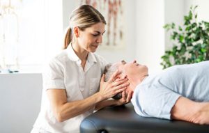 woman treating man on massage table