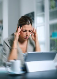 woman holding head in pain