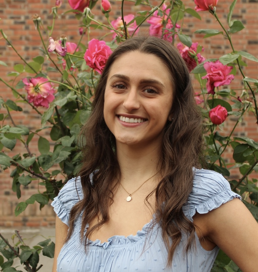photo of jonelle in a blue top with the chico state rose garden in the background